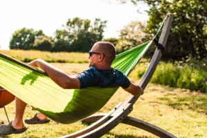 Man relaxing in a hammock at an off-grid digital detox cabin in Sussex