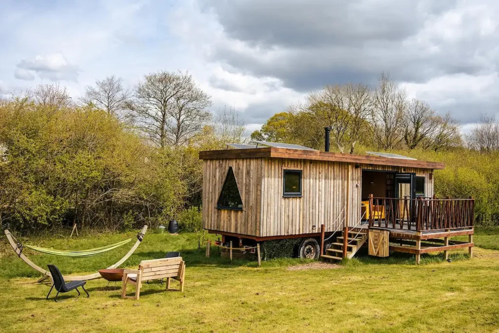 Secluded wooden cabin in a private field with hammock and outdoor seating in Sussex
