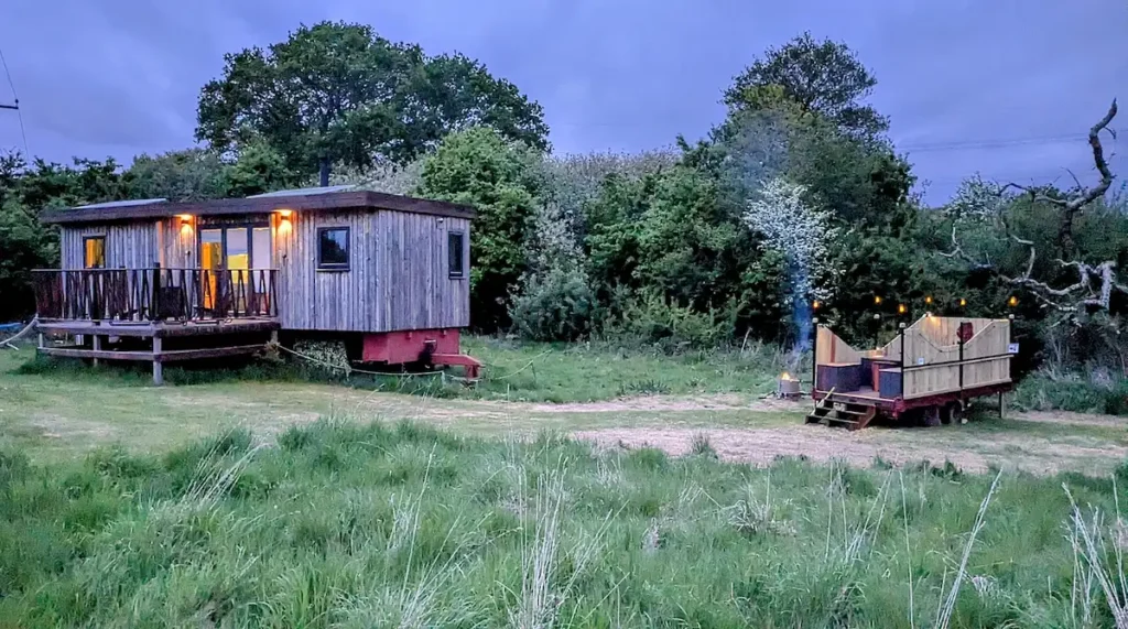 private cabin and wood-fired hot tub trailer set in a secluded Sussex field